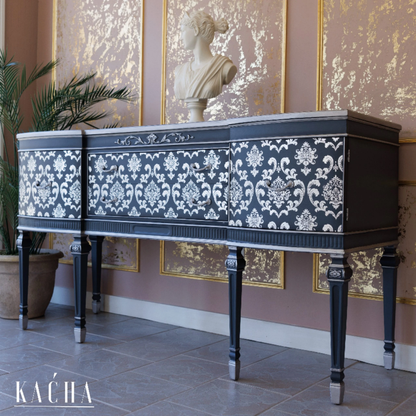 Decorative piano with floral patterns in a room with classical sculptures and artwork.